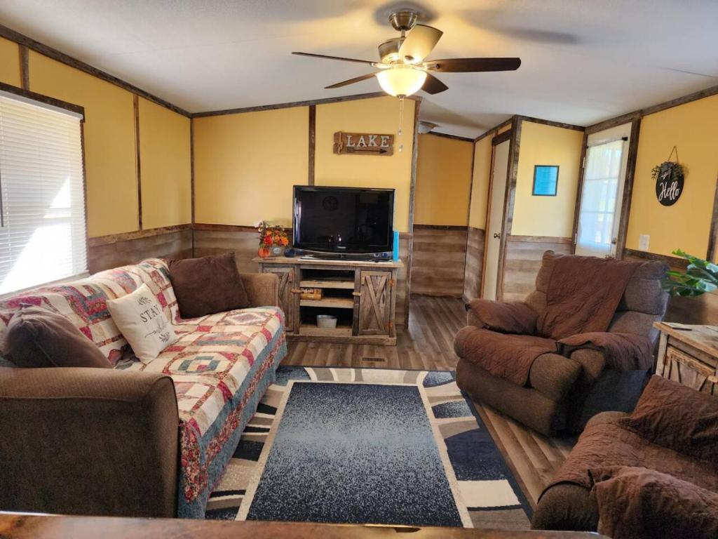 a living room with couches and a flat screen tv at The Holler Inn at Dale Hollow in Frogue