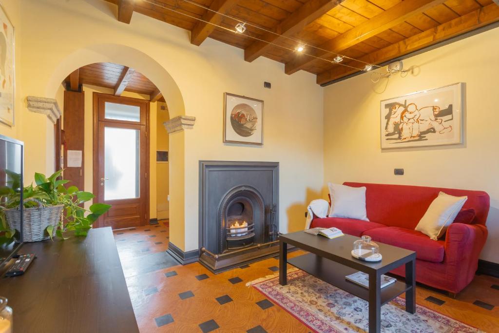 salon z czerwoną kanapą i kominkiem w obiekcie Casa Giovio Lake Como w Como