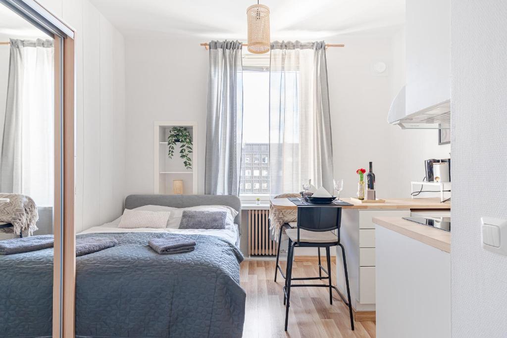 ein Schlafzimmer mit einem Bett und eine Küche mit einem Tisch in der Unterkunft Nordstay - Lovely Central Studio with self check-in in Helsinki