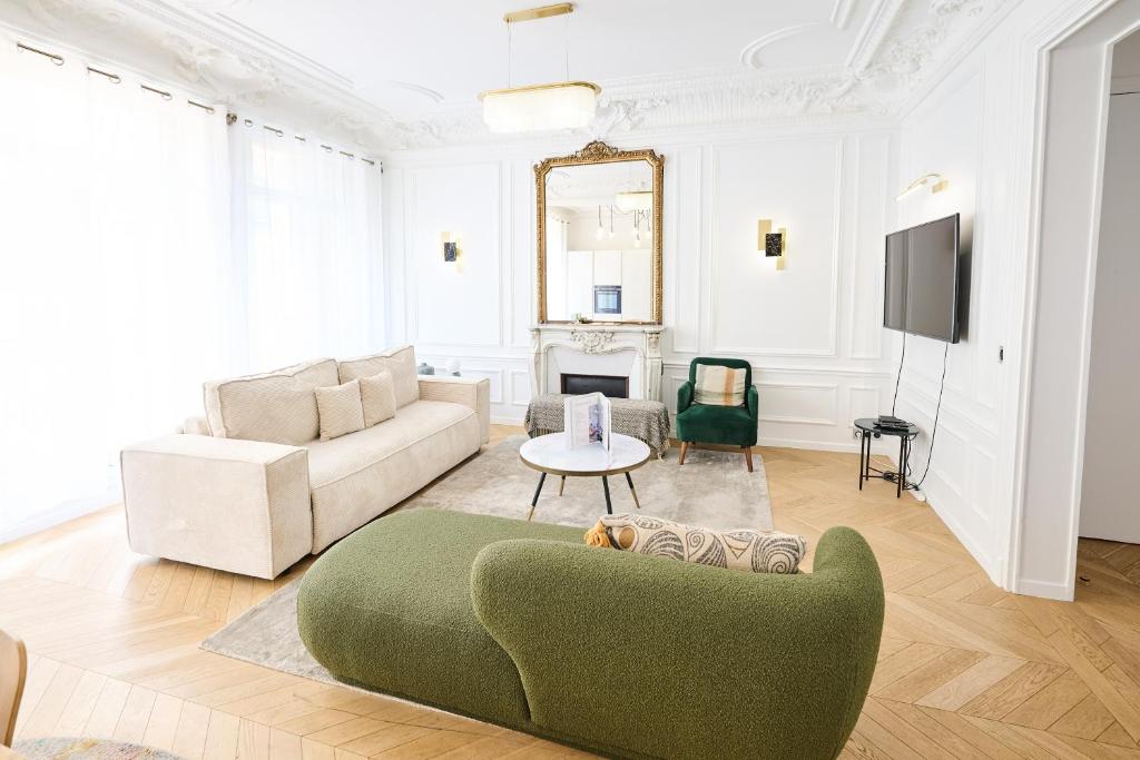 - un salon avec un canapé vert et une télévision dans l'établissement Champs Elysées!Montaigne, New Luxurious 6pers flat, à Paris