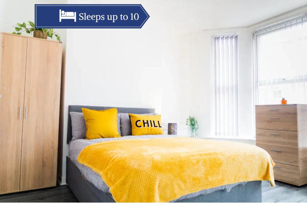 a bedroom with a bed with a yellow blanket at Bright 4BR Home, Perfect for Groups in Liverpool