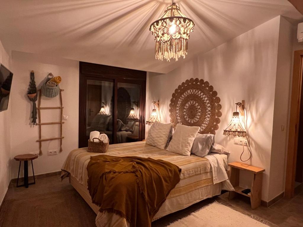 a bedroom with a large bed with a chandelier at Yanes Bed And Breakfast Ronda in Ronda