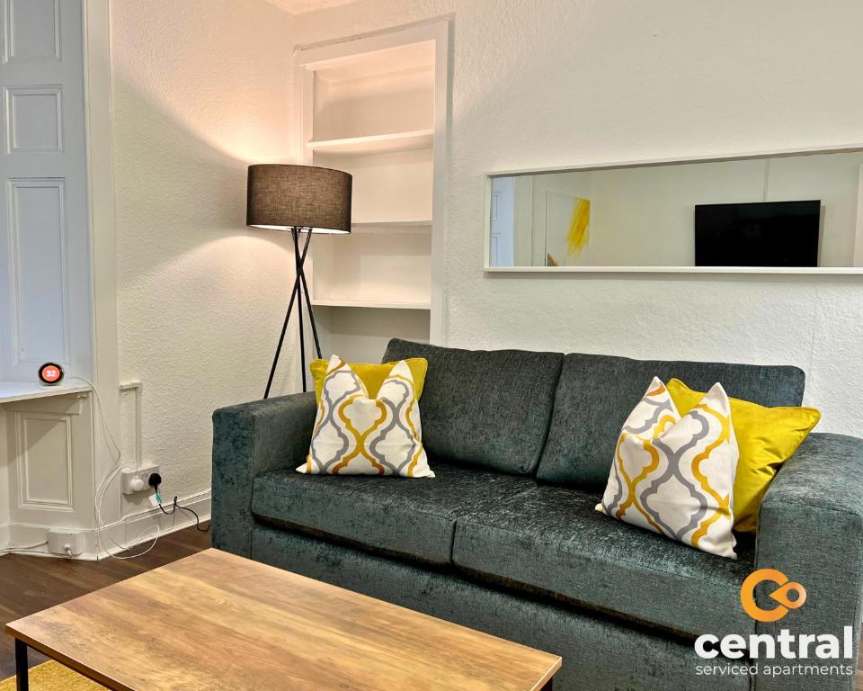 a living room with a gray couch with yellow pillows at 1 Bedroom Apartment by Central Serviced Apartments - Close To University of Dundee - Sleeps 2 - Ground Level - Self Check In - Modern and Cosy - Fast WiFi - Heating 24-7 in Dundee