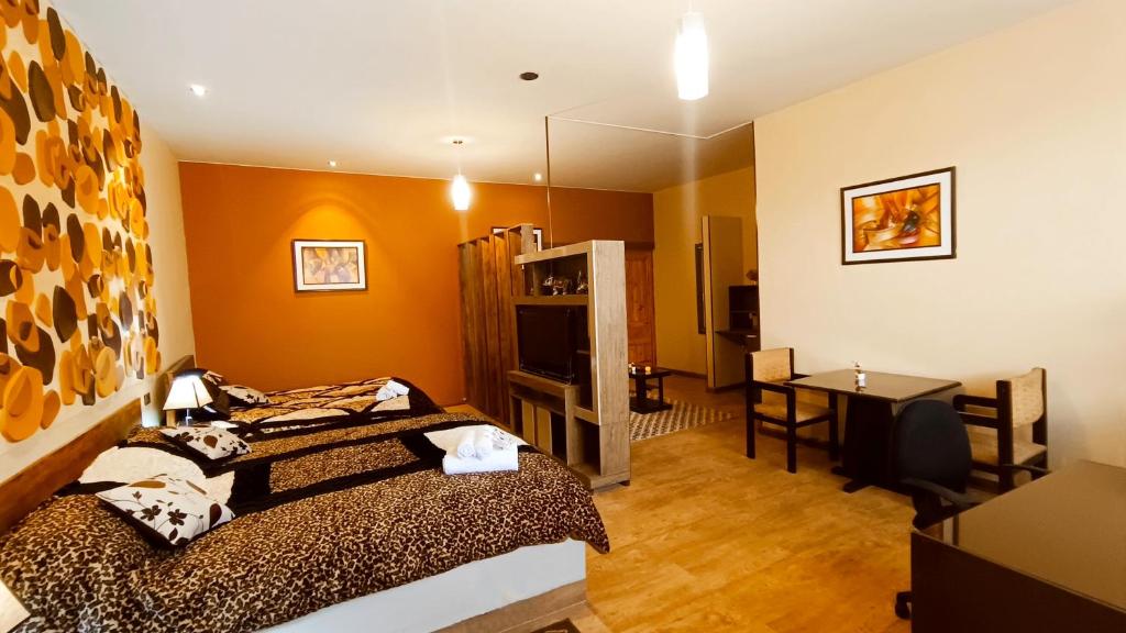 a room with a bed and a desk and a television at HGA-Topacio-Spa in La Paz