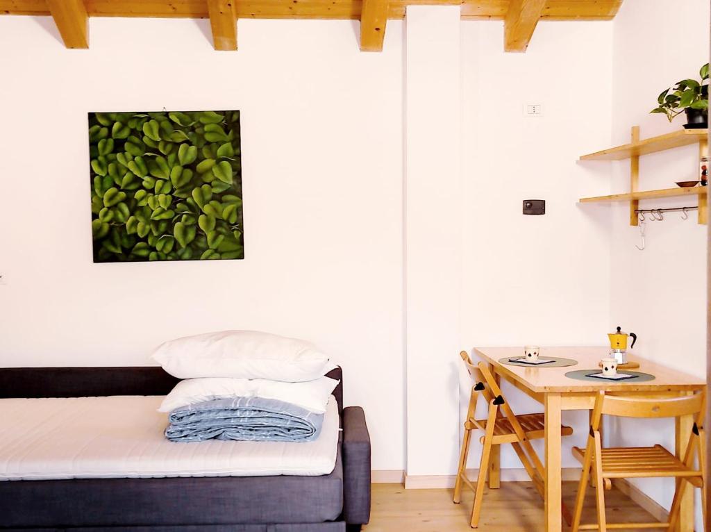Cette petite chambre comprend un lit et une table. dans l'établissement Residence Salvadori, à Rovereto
