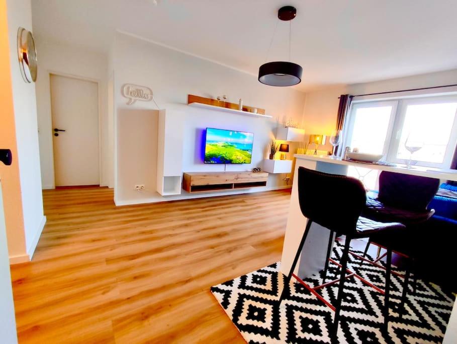 ein Wohnzimmer mit einem TV, einem Tisch und Stühlen in der Unterkunft Neuwertige Wohnung in Top Lage incl. Parkplatz in Magdeburg