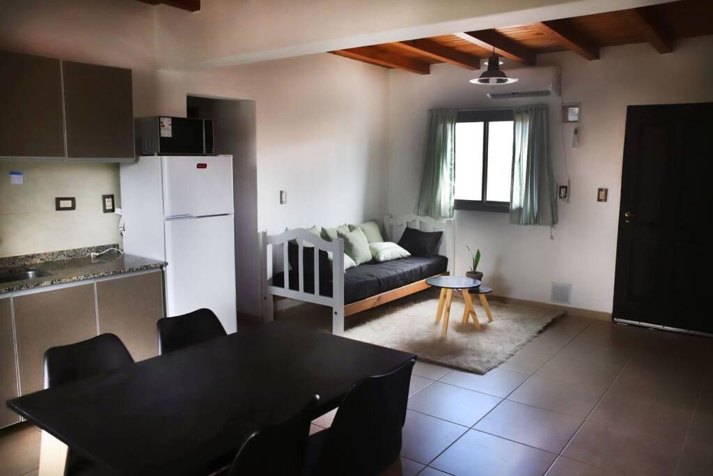 uma cozinha e sala de estar com uma mesa e um sofá em Departamento acogedor en Luján de Cuyo. em Luján de Cuyo