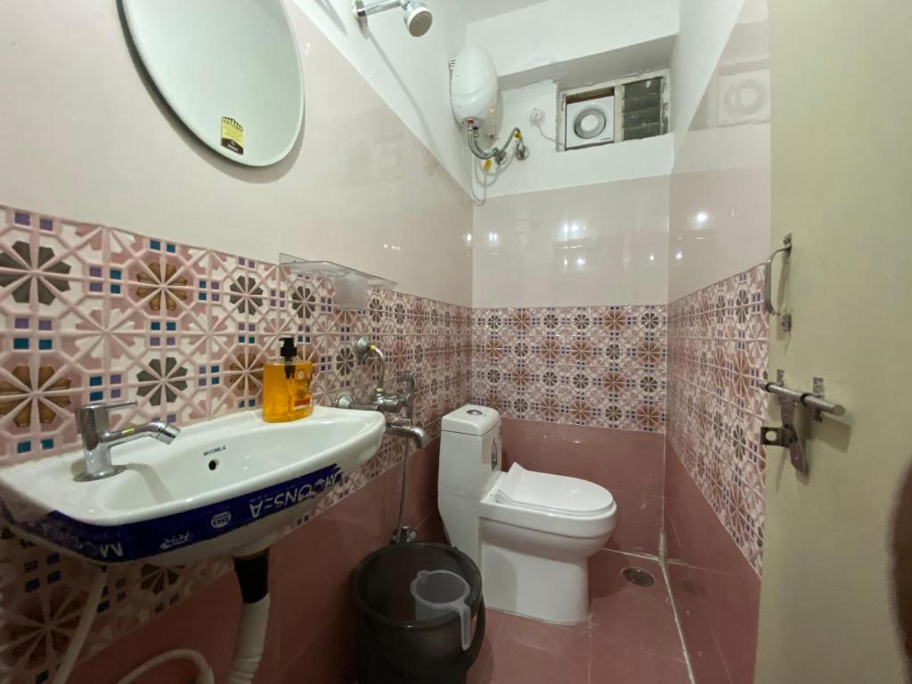 a bathroom with a sink and a toilet at Millennia service apartments in Hyderabad