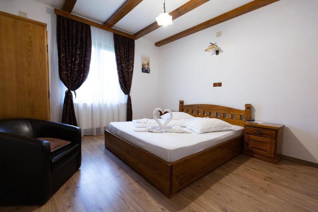 1 dormitorio con 1 cama, 1 silla y 1 ventana en CONACUL DE SUB MUNTE, en Novaci-Străini