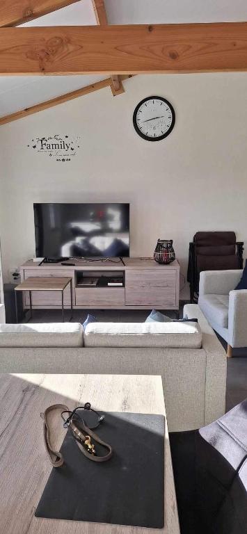 uma sala de estar com um sofá e uma televisão em WH65 gezellig vakantiehuis 4pers. em Koksijde