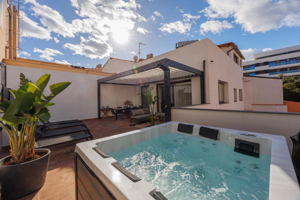 bañera de hidromasaje en la azotea de una casa en Atico Duplex Playa Area Barcelona con SPA exterior, en Montgat