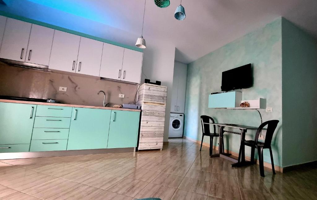 a kitchen with a table and chairs and a television at Diego Rooms Vlora in Vlorë
