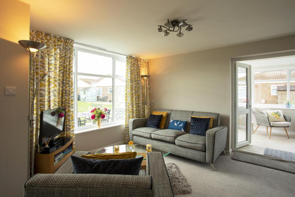 uma sala de estar com um sofá e uma televisão em Harbour cottage sleeps 4 nr Marina Eastbourne em Pevensey