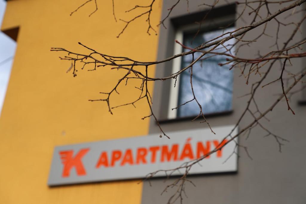 a sign on the side of a building with a window at Kolík Apartmány in Bohumín