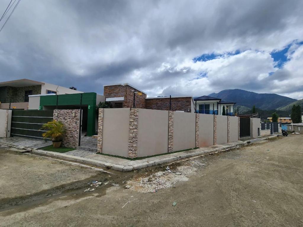 eine Reihe von Häusern auf einer Straße mit einem Zaun in der Unterkunft Seguridad con buen ambiente in Concepción de La Vega