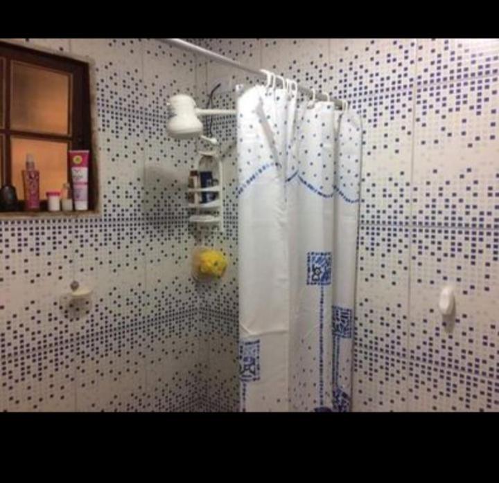 y baño con ducha y cortina de ducha. en Vila Torres, en Cachoeiras de Macacu