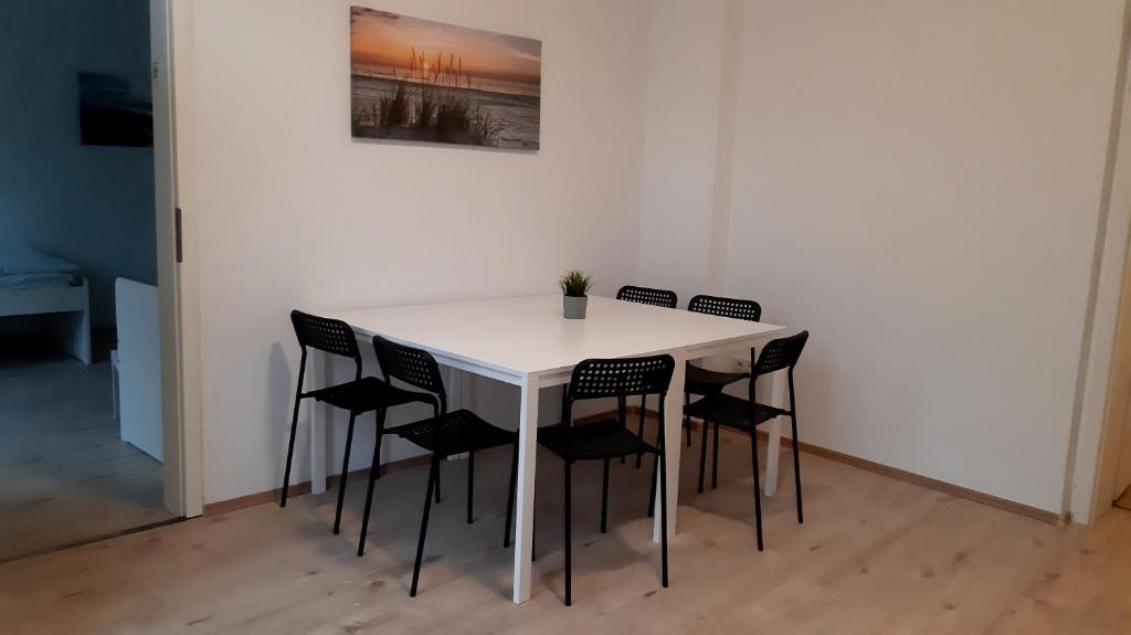 a white table with black chairs in a room at Wohnung für 6 Personen in Gevelsberg in Gevelsberg