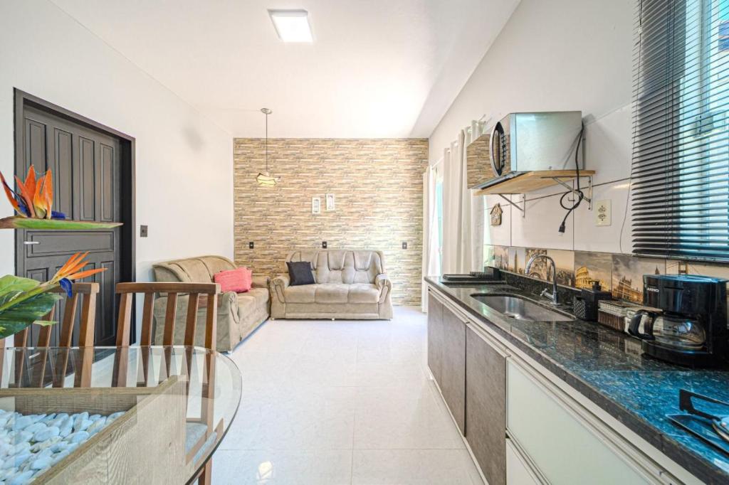 uma cozinha com um balcão e uma sala de estar em Confortavel espaçoso Lof para familia em Joinville