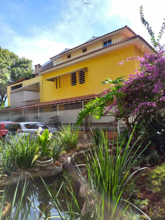 una casa amarilla con autos estacionados frente a ella en KzaZenDF CamaeCafé AsaSul, en Brasilia