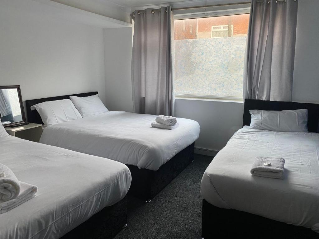 a room with two beds and a window at The Regency Hotel in Blackpool