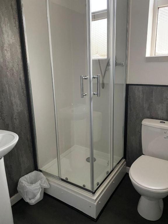 a bathroom with a shower with a toilet and a sink at The Regency Hotel in Blackpool