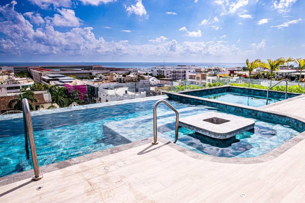 a swimming pool on the roof of a building at Ocean view Studio, Rooftop Pool, steps from beach Hyatt in Playa del Carmen