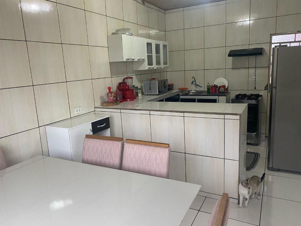 a kitchen with a table and chairs and a cat in it at Casa de Everton e Tati in Triunfo