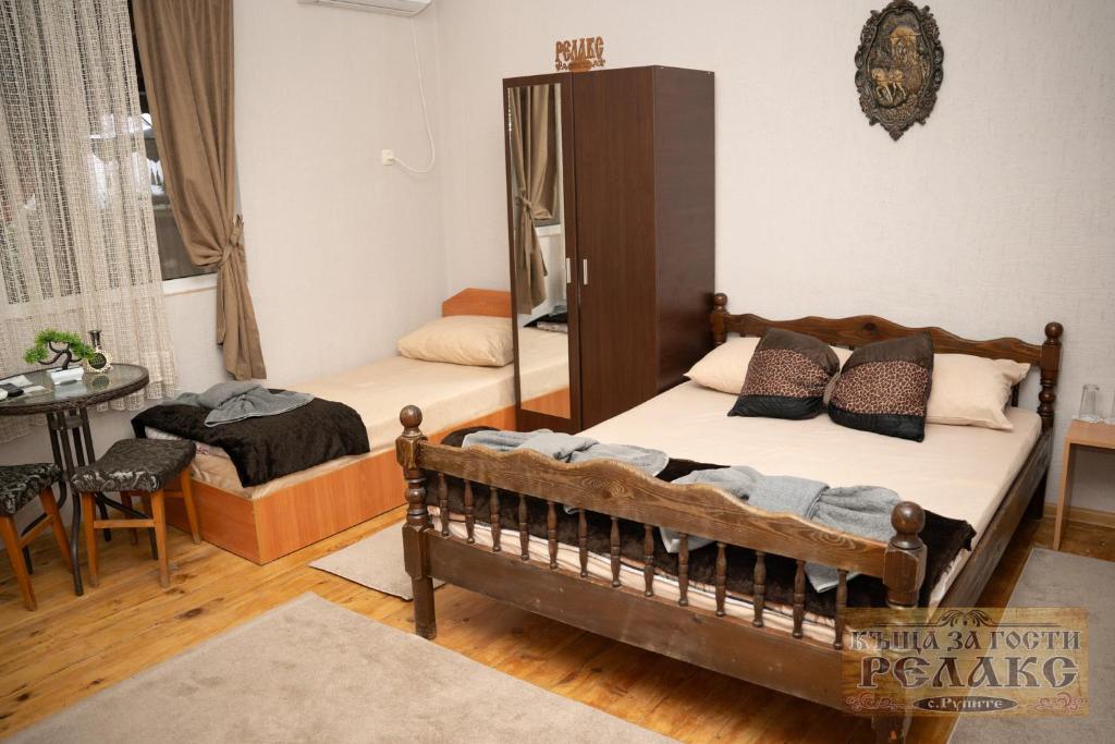 a bedroom with two beds and a mirror at Къща за гости Рупите , Guest House Relax Rupite in Rupite
