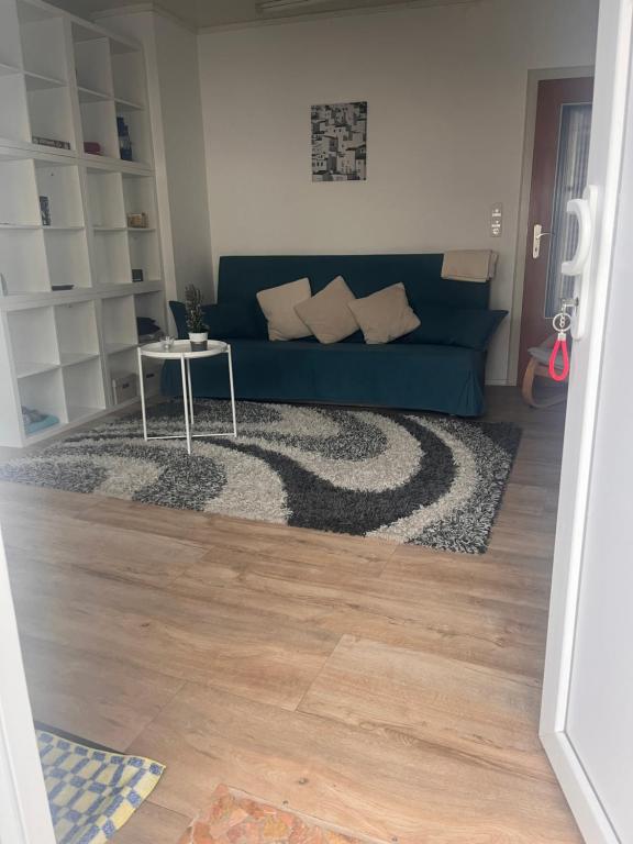 a living room with a blue couch and a table at Ferienwohnung am MeetingPoint in Weilmünster