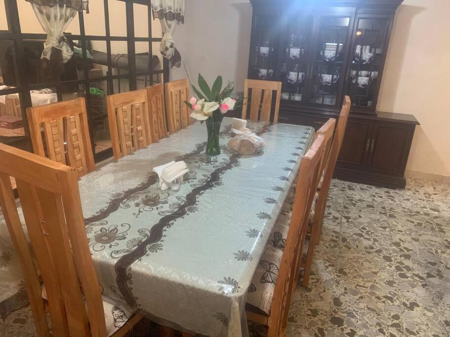 a table with a blue table cloth and a vase of flowers at Freddy's Suite in Ciudad Nezahualcóyotl