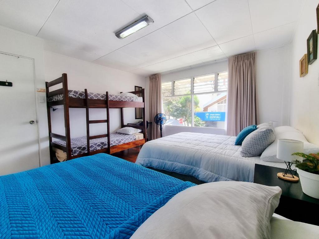 1 dormitorio con 2 camas y ventana en Casa Jardin del Mango, en San José