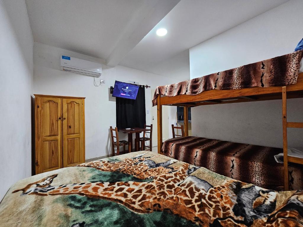 a bedroom with a giraffe blanket on a bed at Hospedaje Los 7 Arcangeles in Termas de Río Hondo