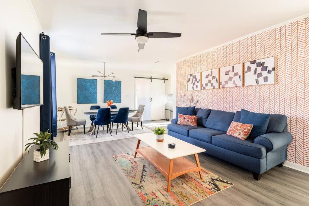 uma sala de estar com um sofá azul e uma mesa em 4 Bedroom Bungalow - 5 min to Uptown Charlotte em Charlotte