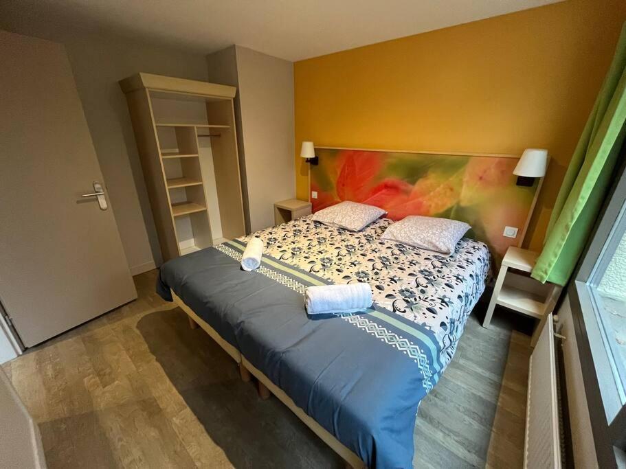 Schlafzimmer mit einem Bett mit blauer Bettwäsche und Kissen in der Unterkunft Cottage 4p-Les Hauts de Bruyères-756 in Chaumont-sur-Tharonne