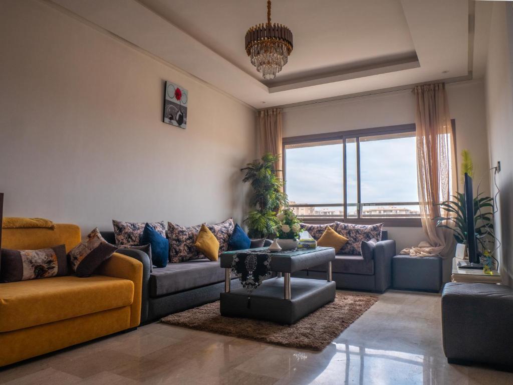 a living room with couches and a large window at Luminous & cosy studio - 5 mins from Mohammed V Airport in Nouaceur
