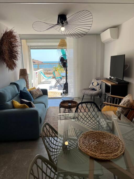 un salon avec une table en verre et des chaises dans l'établissement Bel appartement pieds dans l’eau, à Sète