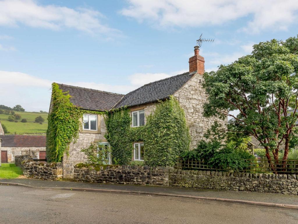 a stone house with ivy growing on it at 4 Bed in Brassington 85450 in Brassington