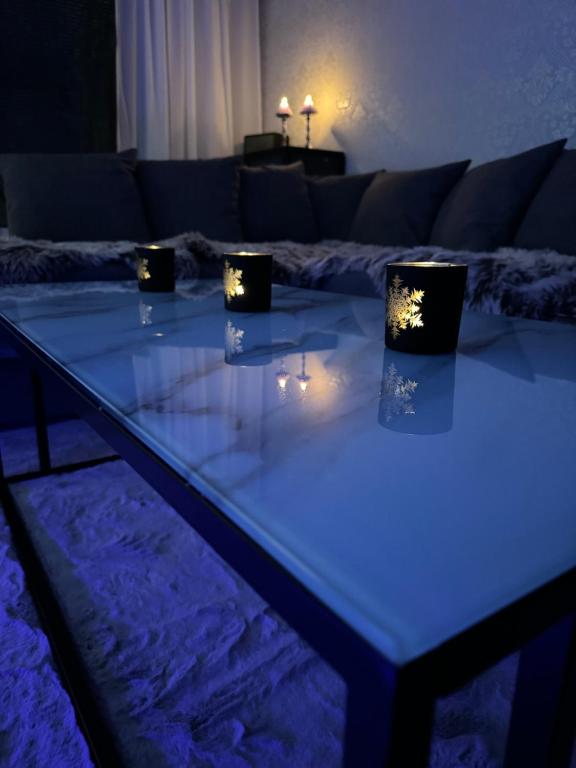 een tafel in de woonkamer met verlichting bij Rubin Apartment in Kajaani