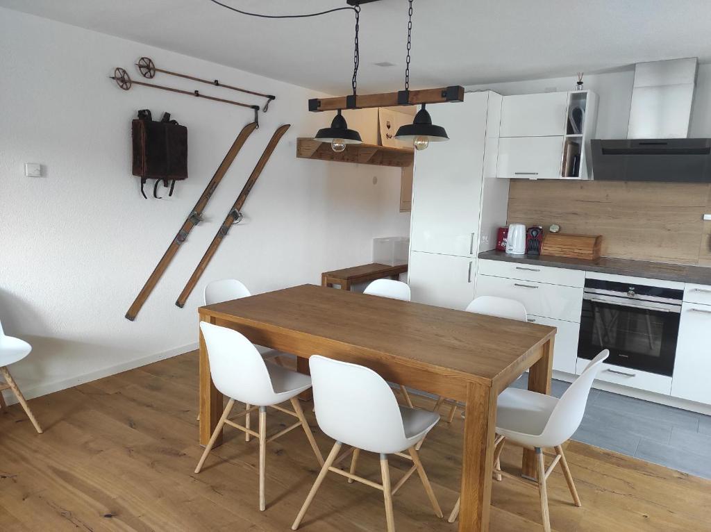 cocina con mesa de madera y sillas blancas en Haus Rhätikon 1. OG, links, en Davos