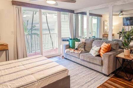 ein Wohnzimmer mit einem Sofa und einem großen Fenster in der Unterkunft Beachfront Condo with AC in Laie