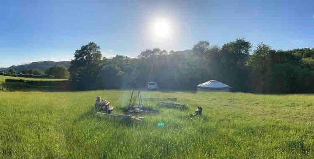 eine Gruppe von Menschen auf einem Feld mit einem Zelt in der Unterkunft Wilding Yurt Stay in Broughton in Furness