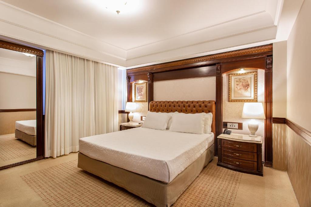 a hotel room with a bed and a mirror at Bourbon Londrina Business Hotel in Londrina