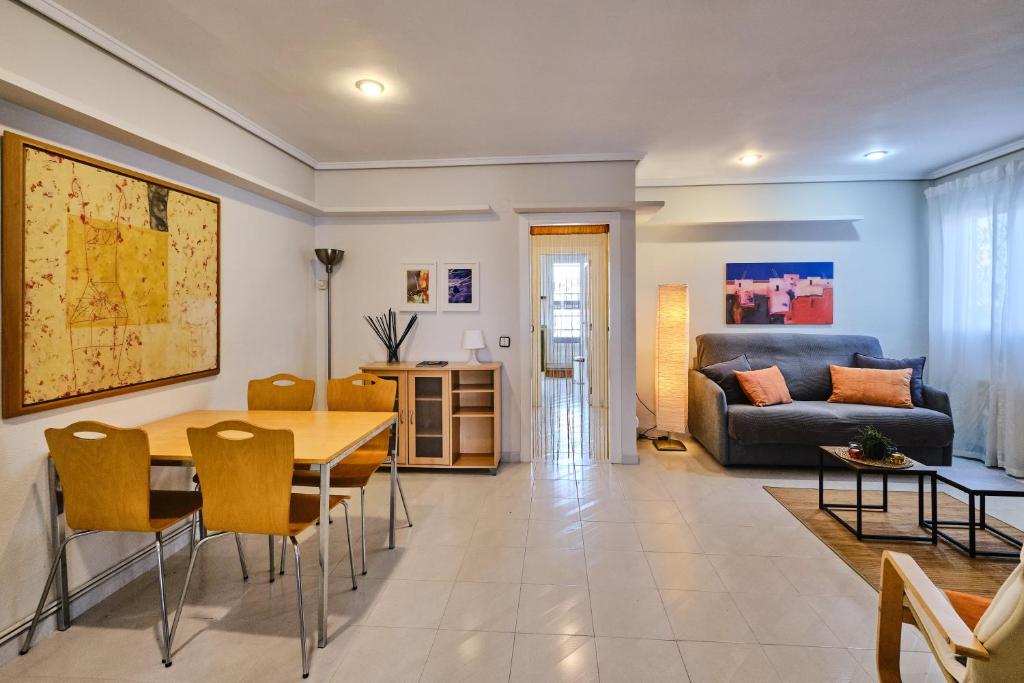 ein Wohnzimmer mit einem Tisch, Stühlen und einem Sofa in der Unterkunft Penthouse Inlakesh in Valencia
