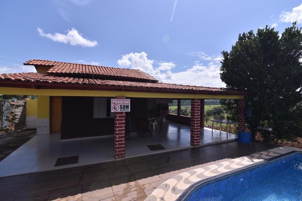 uma casa com piscina e um sinal de limite de velocidade em Recanto Minas a Goiás em Ceres