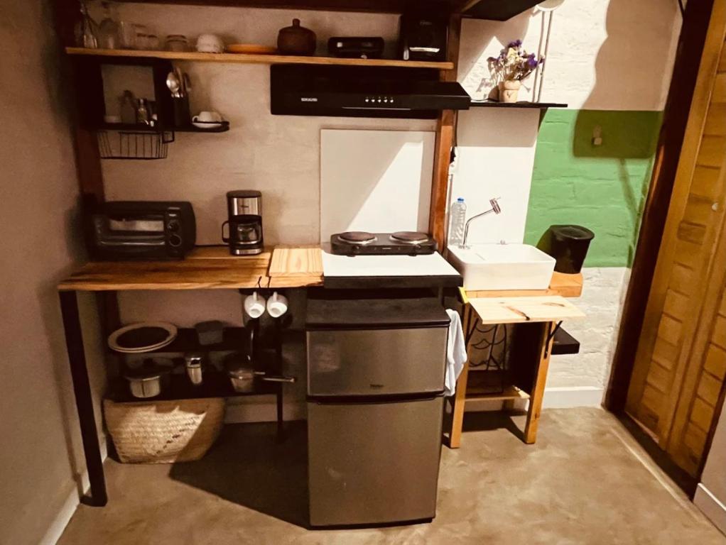 a small kitchen with a stove and a sink at Yê Tiny Houses in Palmeiras