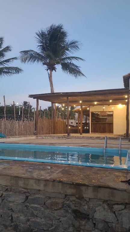 una piscina frente a un edificio con palmeras en Casa Monã, en Maceió