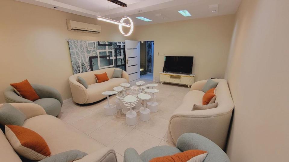 een woonkamer met banken en een flatscreen-tv bij شـاليــه غـيــم in Riyad