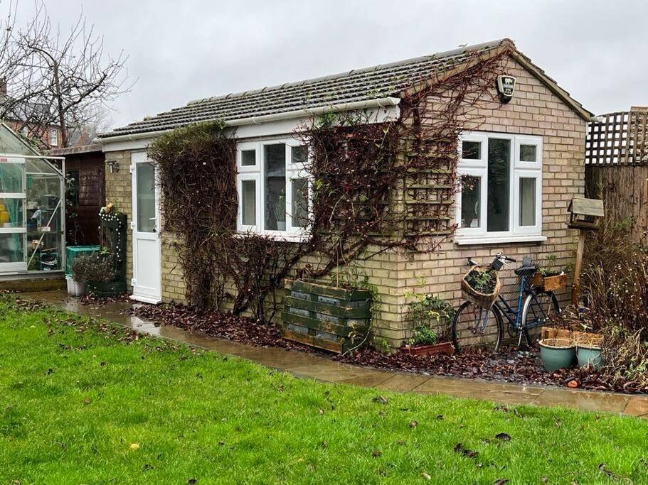 a small house with vines growing on the side of it at Self Contained Annex in Potterspury