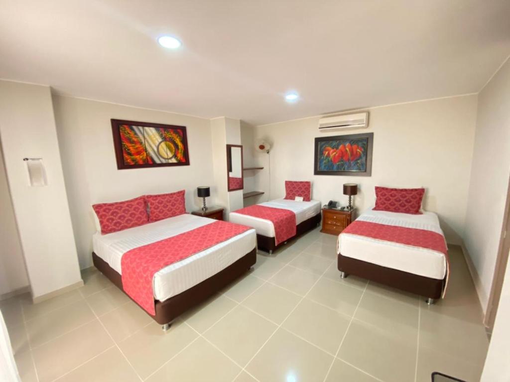 two beds in a room with red and white at Cabecera Country Hotel in Bucaramanga