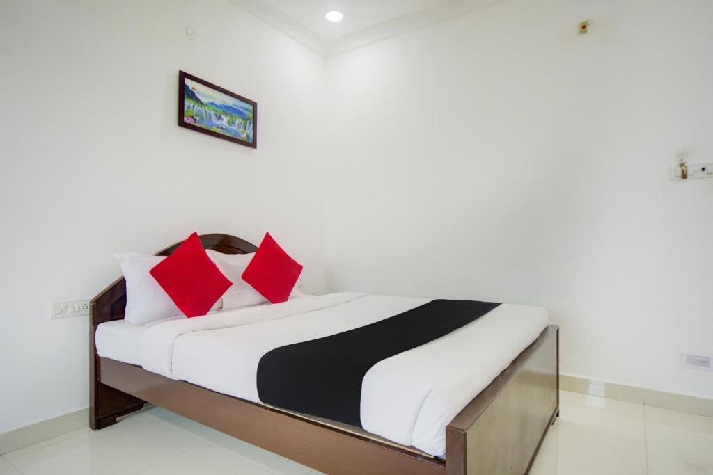 a bedroom with a bed with red and black pillows at Collection O Aar Bee Gee Hotel in Gummidipūndi